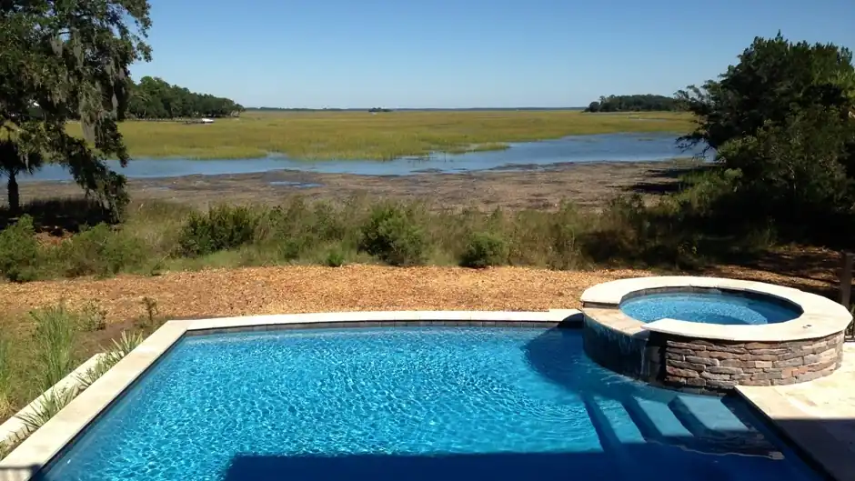 Pool and raised spa looking across marsh grass