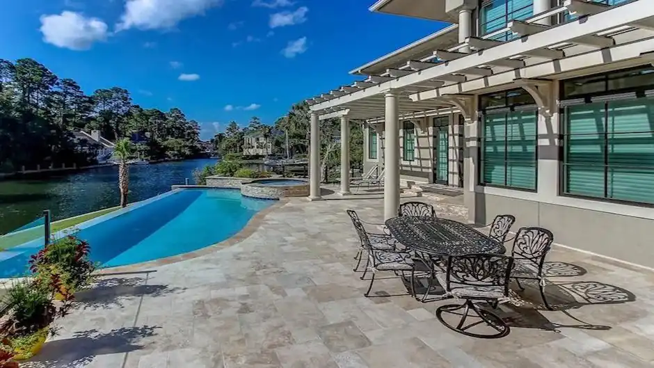 Infinity-edge pool looking toward a sailboat dock